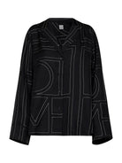 Black TOTEME silk pajama shirt with embroidered monogram, front view