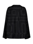 Black TOTEME silk pajama shirt with lapel collar and mother-of-pearl buttons, detail view