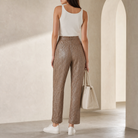 Beige metallic tapered trousers back view showing relaxed tapered leg silhouette