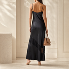 Black satin slip dress back view showing bias-cut construction