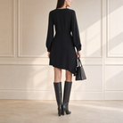Black wrap mini dress with blouson sleeves and buttoned cuffs, back view