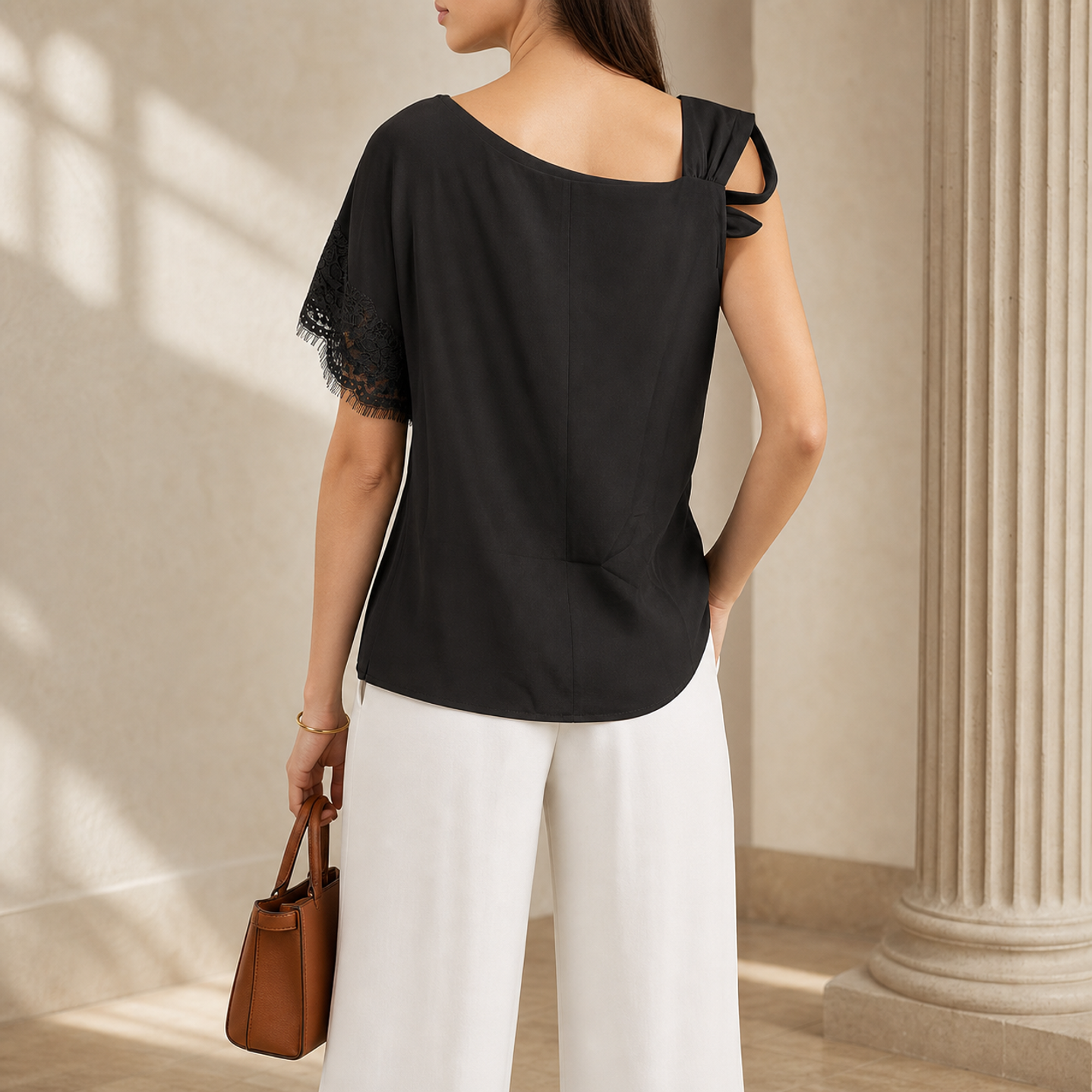 Black one-shoulder top showing lace trim sleeve detail, close-up back