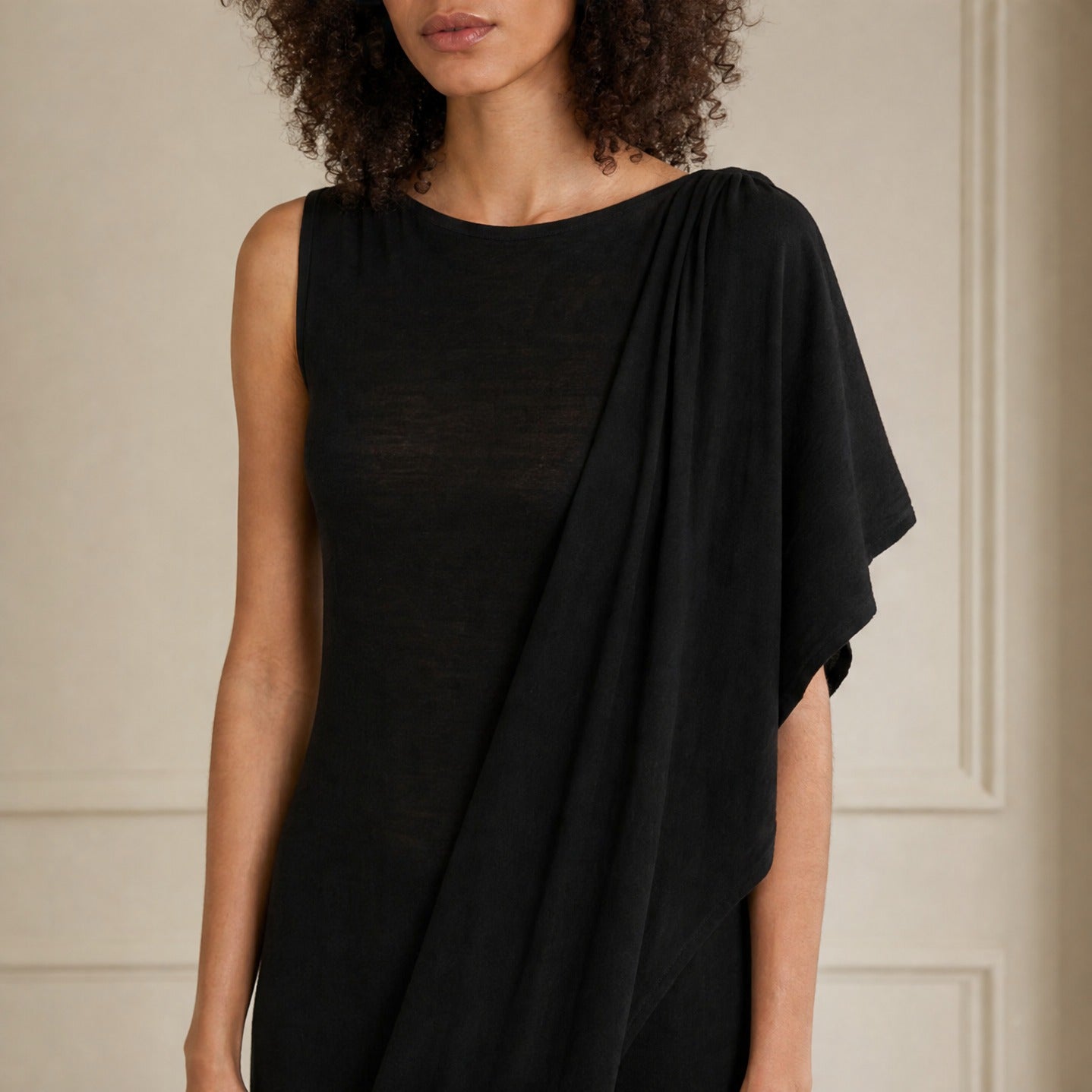 Black merino wool dress by PALOMA WOOL, close-up front detail of asymmetric draping