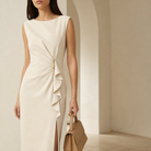 Cream structured crepe dress front detail showing gold-tone bar and asymmetric ruching