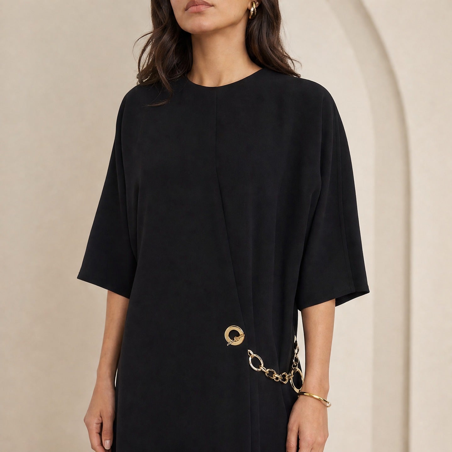 Black Celine wrap dress crew neckline and gold chain detail, close-up front