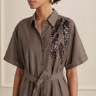 Embroidered detailing on brown cotton blend dress, front close-up