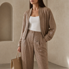 Beige metallic trousers high-rise waist detail with button and zip fastening, close-up
