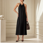 Black halter maxi dress with chain detail by Lord & Taylor Heritage, full-length side view on model