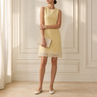 Butter yellow sleeveless shift dress by Lord & Taylor Heritage, full-length side view on model