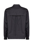 Black C.P. Company overshirt showing chest patch pocket and snap-button placket detail