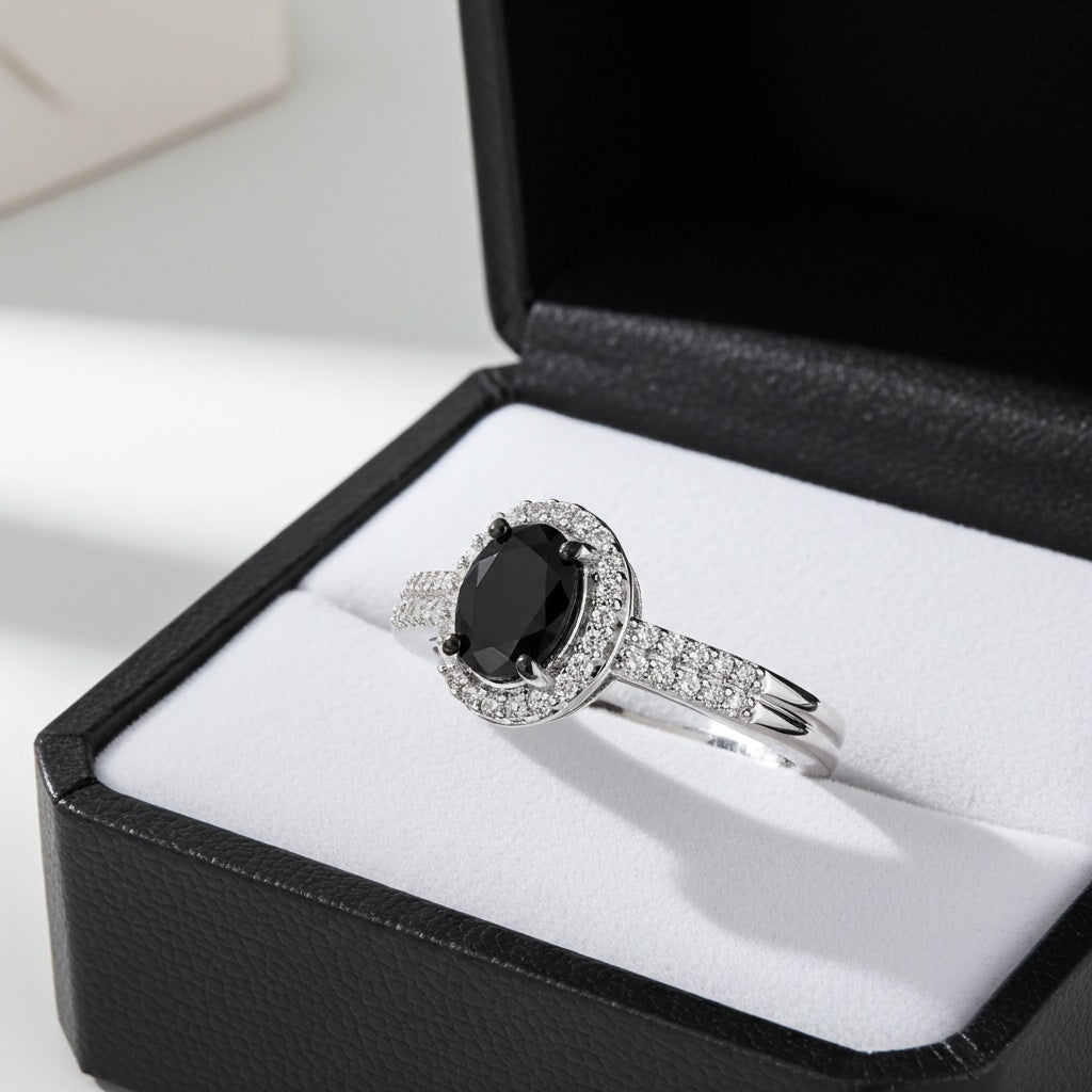 White gold oval halo engagement ring with black diamond center by Delmar, angled view