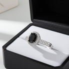 White gold oval halo engagement ring with black diamond center by Delmar, angled view